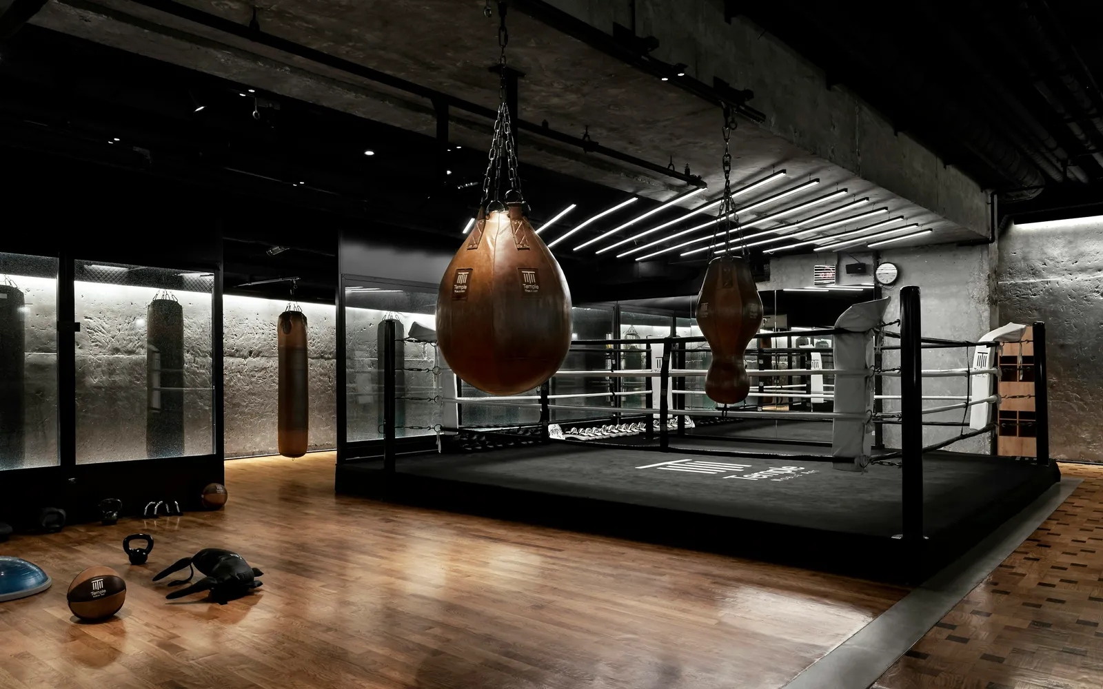 A fitness studio floor with a boxing ring